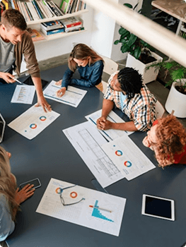 Team planning around a table of printouts